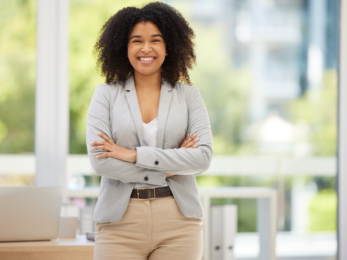 woman standing with arms crossed smiling