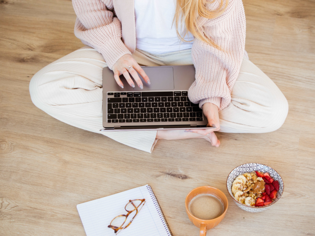 woman sitting on the floor typing in laptop